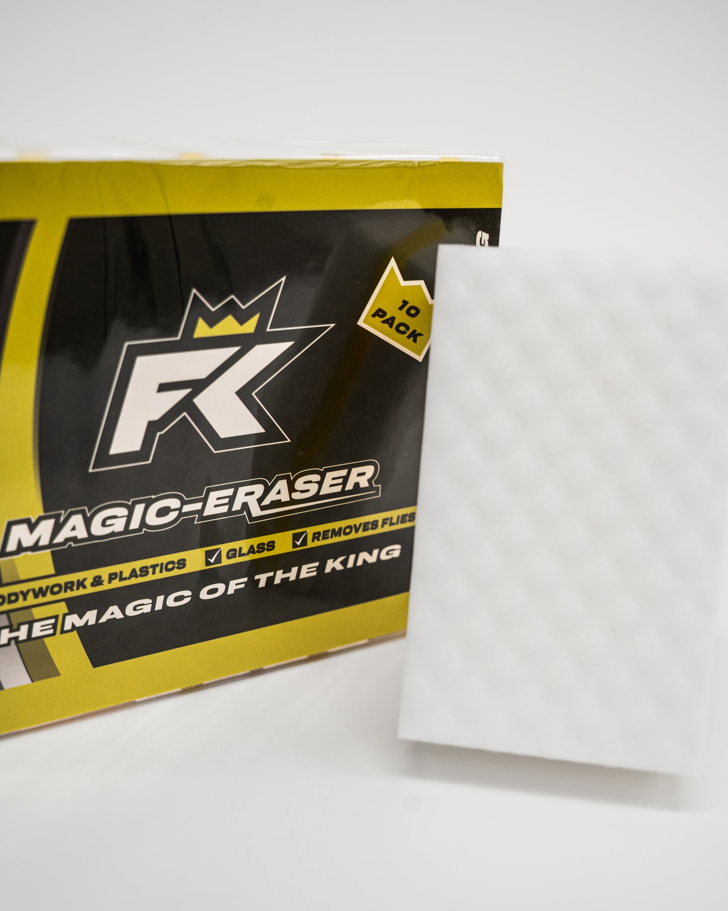 A white textured FibreKing Magic Eraser melamine sponge stands upright beside a yellow and black box labeled Magic Eraser (10 per pack), ideal for motorsport cleaning.