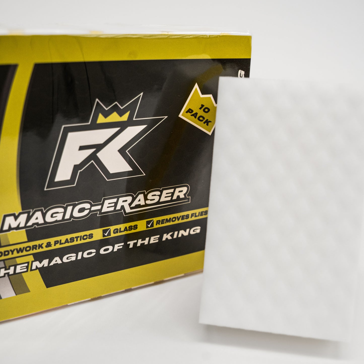 A white textured FibreKing Magic Eraser melamine sponge stands upright beside a yellow and black box labeled Magic Eraser (10 per pack), ideal for motorsport cleaning.
