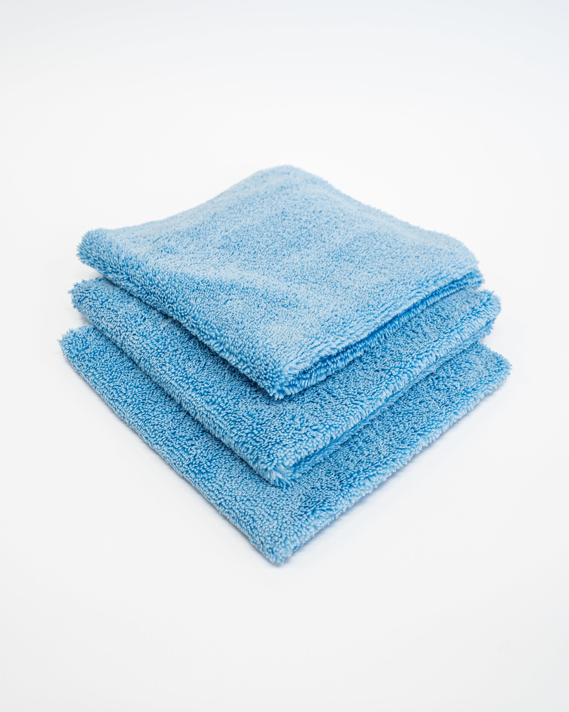 Three FibreKing Duplex edgeless cloths (3 pack) in blue dual pile microfiber are neatly folded and stacked against a plain white background.
