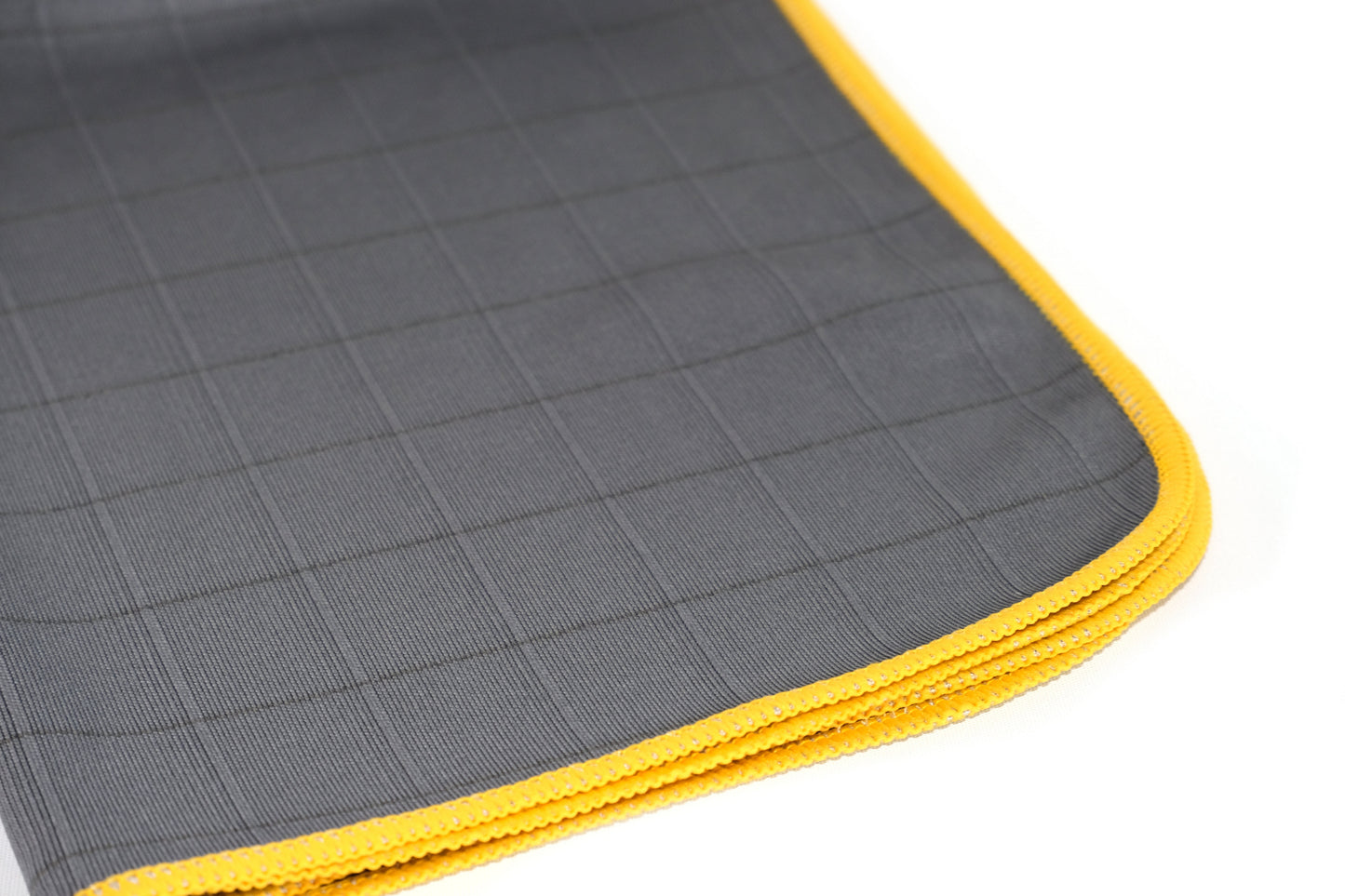 Close-up of FibreKing Carbon Glass Cloths (3 Pack), anti-static microfiber in gray with a subtle grid pattern and yellow border, folded neatly on a white background.