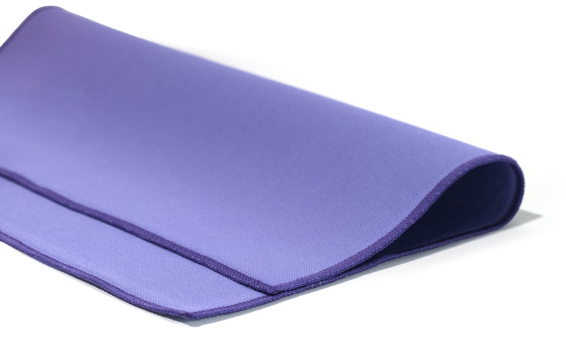 A close-up of a rolled purple yoga mat beside FibreKing Gold Label Korean Glass Cloths (3 Pack), recognized for their premium microfibre quality and streak-free finish, on a white background.