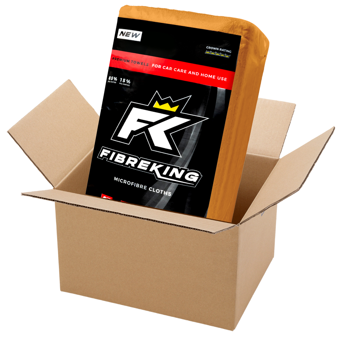 A FibreKing Silver Label 325GSM microfibre cloth box (10 packs of 36), partially wrapped in orange, sits in an open brown cardboard box—ideal for car cleaning and machine washable.