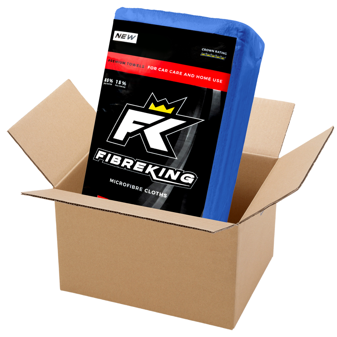 A box of FibreKing Silver Label 325GSM microfibre cloths (10 packs of 36) in blue packaging sits partially inside an open shipping box—perfect for car cleaning.
