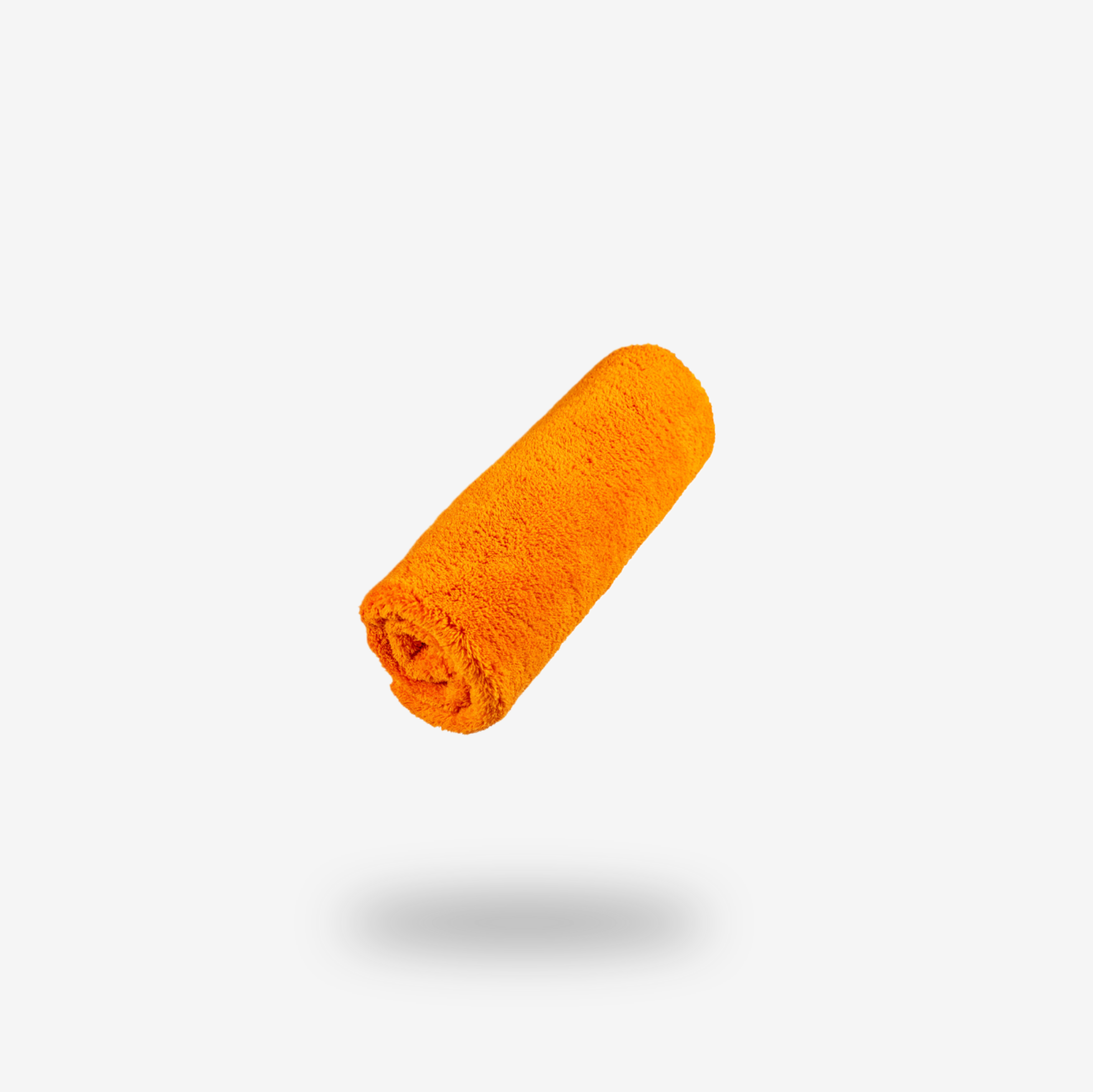 A rolled-up FibreKing Ultimate Detailer Cloth in orange coral fleece microfiber is centered on a plain white background with a faint shadow beneath it.
