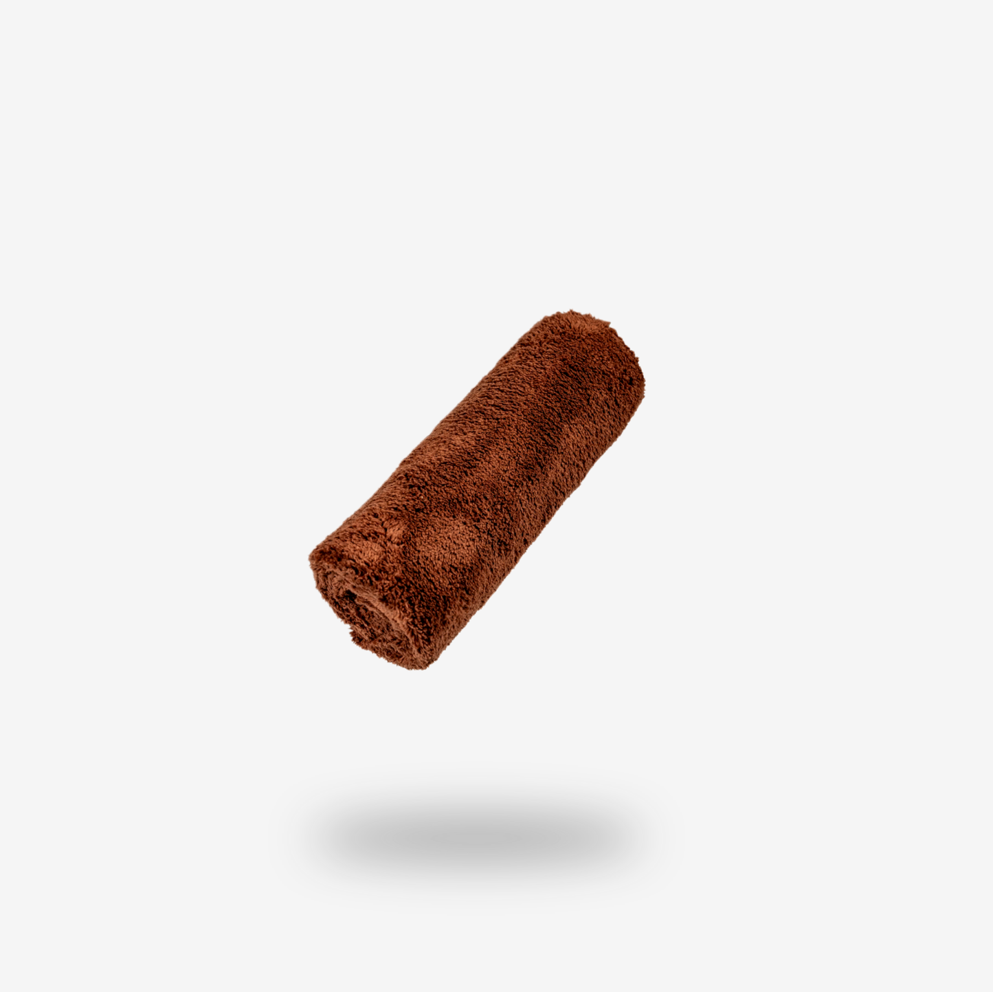 A rolled-up FibreKing Ultimate detailer cloth (Brown) floats above a light gray background, casting a shadow beneath it.