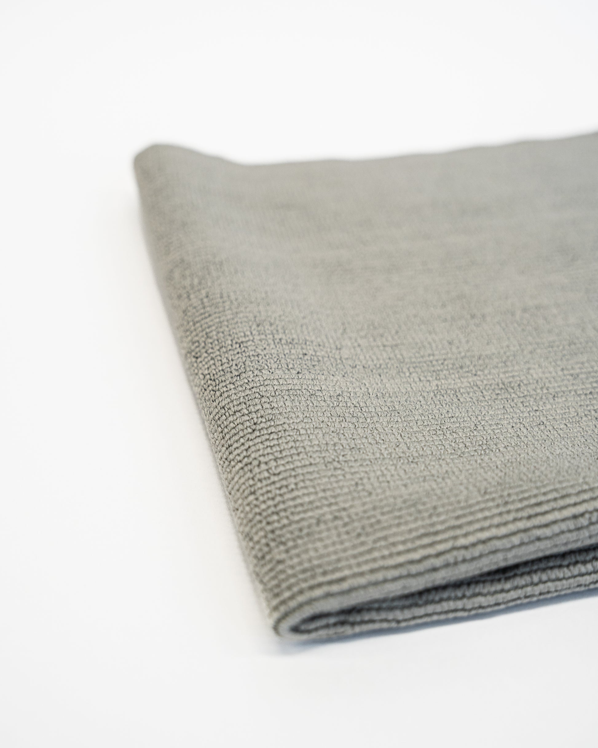 A folded FibreKing Soft Edgeless Multi-Purpose Microfibre Cloth in gray rests on a white surface.