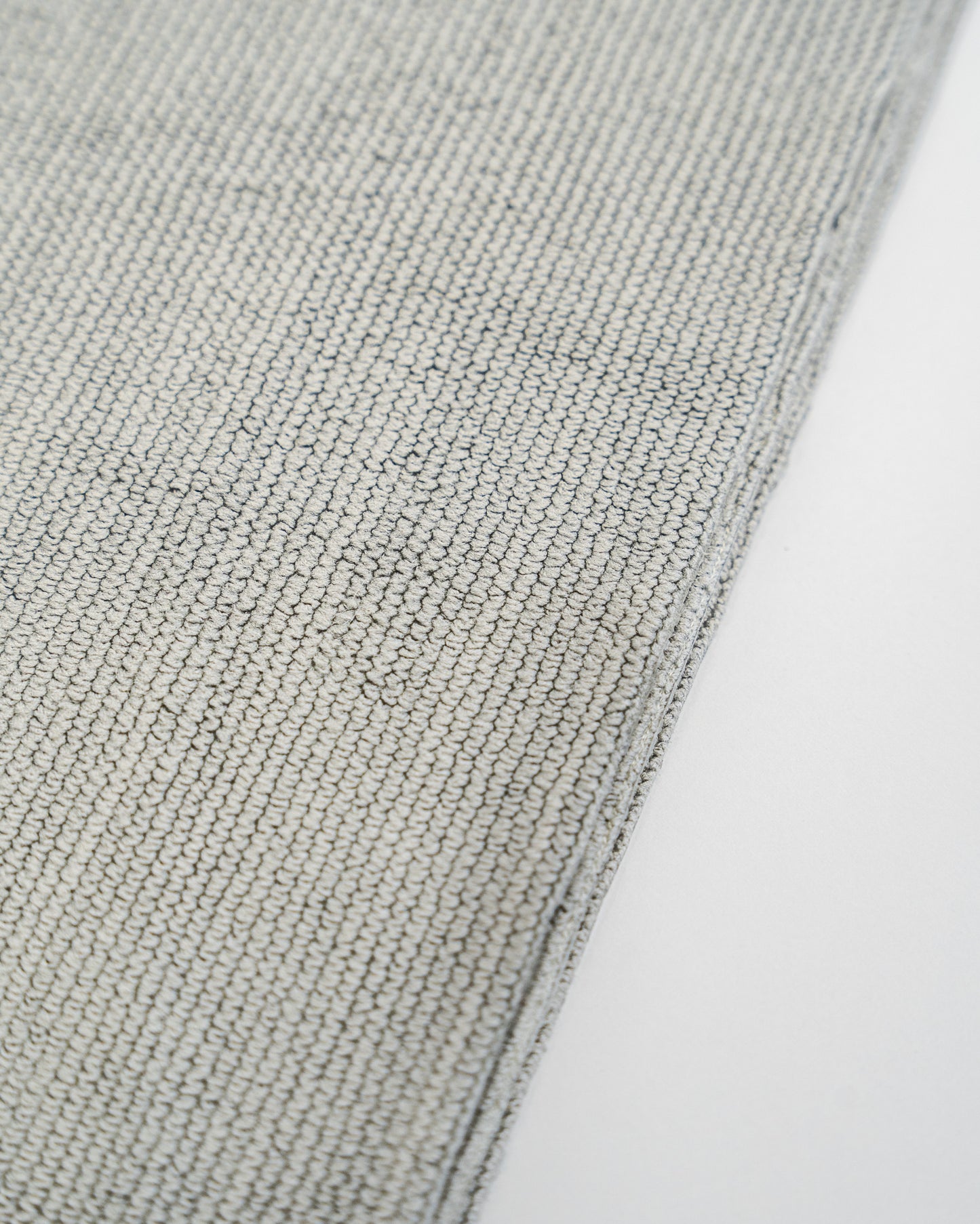 Close-up of the FibreKing Soft Edgeless Multi-Purpose Microfibre Cloth shows its textured, light gray woven fabric and seamless edge, set against a white background.