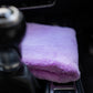 A FibreKing Ultimate detailer cloth, folded and lint-free in purple, sits on the car’s center console beside the gear shift.