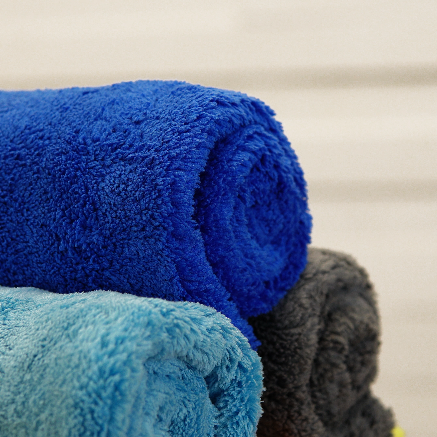 A close-up shows three FibreKing Ultimate Detailer Cloths (blue, light blue, and gray) from the 3-pack multipack, ultra-soft and stacked neatly against a neutral background.