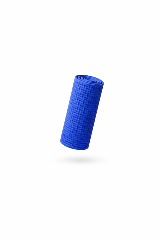 A rolled-up blue yoga mat with a textured surface sits centered on a white background, casting a faint shadow below—its pattern evokes the signature look of FibreKing’s Waffle Weave Towels (3 Pack).