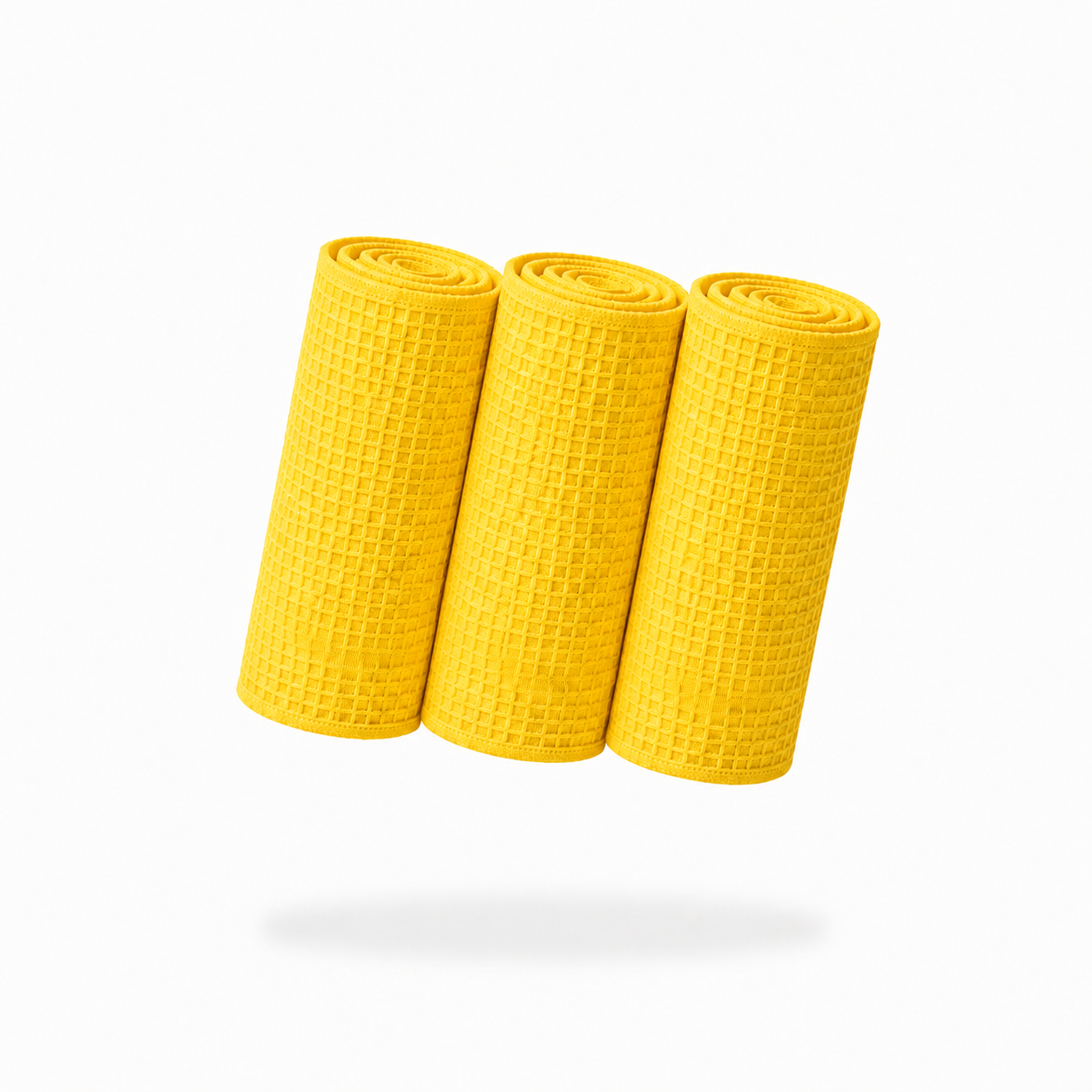Three FibreKing yellow Waffle Weave Towels (3 Pack) are rolled up and standing side by side on a plain white background, casting a shadow below.
