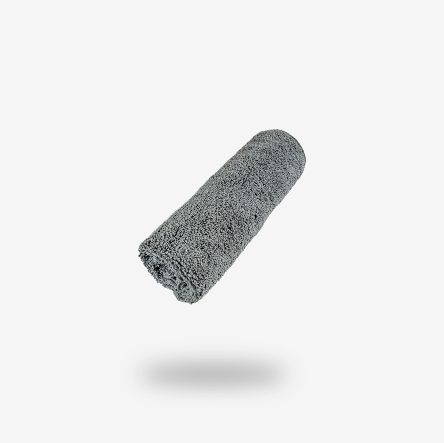 A rolled-up grey FibreKing cleaning cloth from the Build Your Own Gold label Pack floats above a white background, casting a soft shadow.