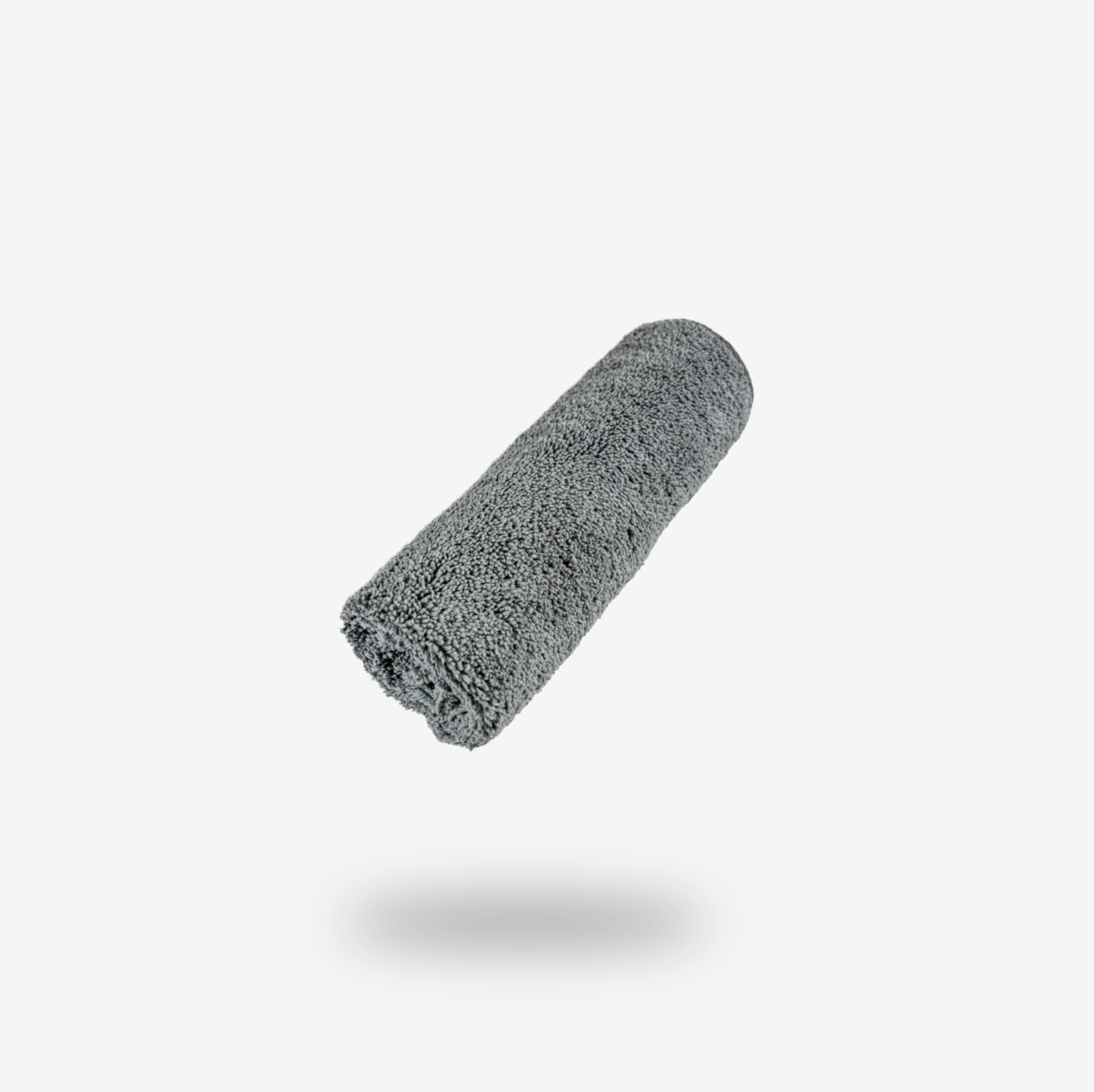 A rolled-up grey FibreKing cleaning cloth from the Build Your Own Gold label Pack floats above a white background, casting a soft shadow.