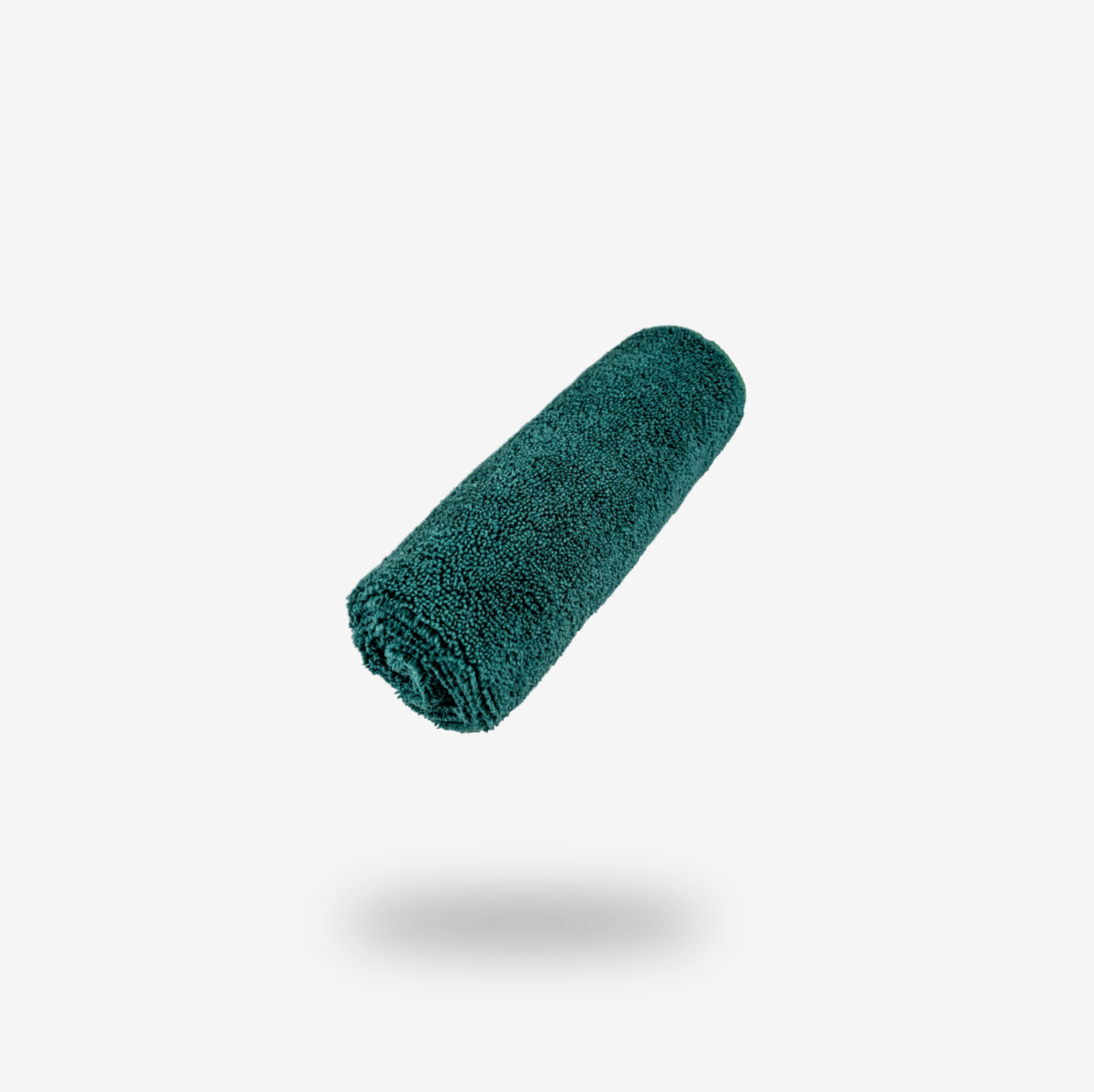 A rolled-up turquoise FibreKing Build Your Own Gold label Pack cleaning cloth floats against a plain white background with a soft shadow below.